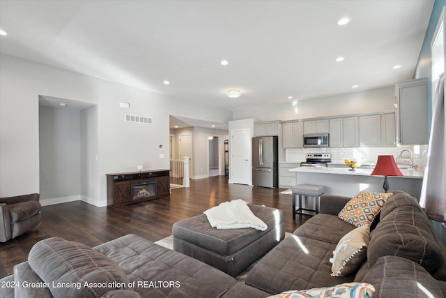 living room with dark wood-type flooring and sink