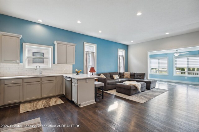 kitchen with a kitchen breakfast bar, sink, kitchen peninsula, and dark hardwood / wood-style flooring