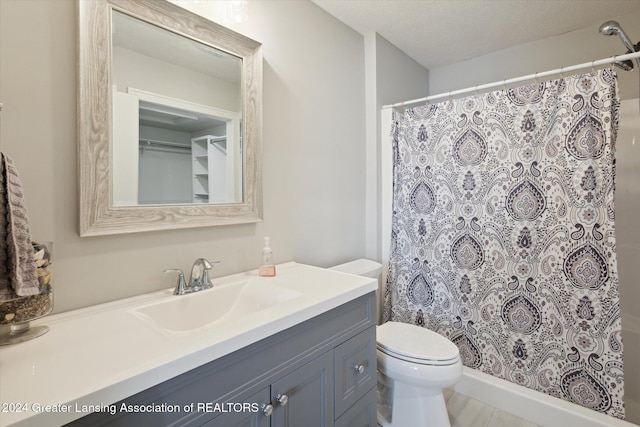 bathroom with toilet, curtained shower, and vanity