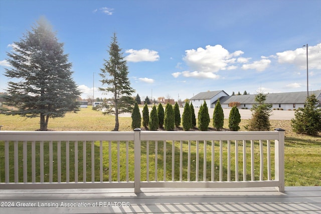 wooden deck featuring a lawn