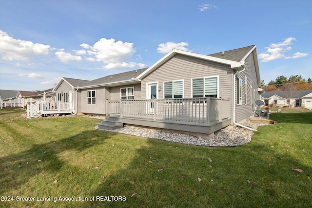 rear view of house featuring a deck and a lawn