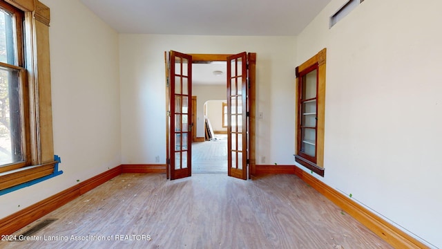 empty room featuring french doors and light wood-type flooring