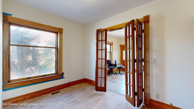 empty room featuring light wood-type flooring and french doors