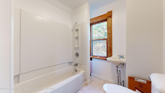 bathroom with toilet and bathing tub / shower combination