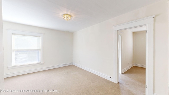 unfurnished room featuring light colored carpet