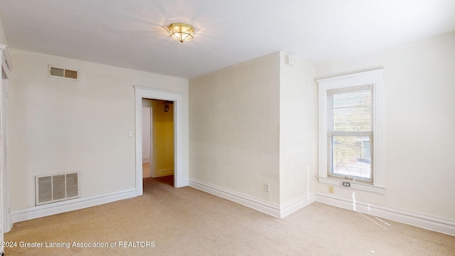 spare room featuring light colored carpet