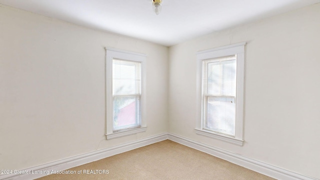 empty room with a healthy amount of sunlight and carpet floors