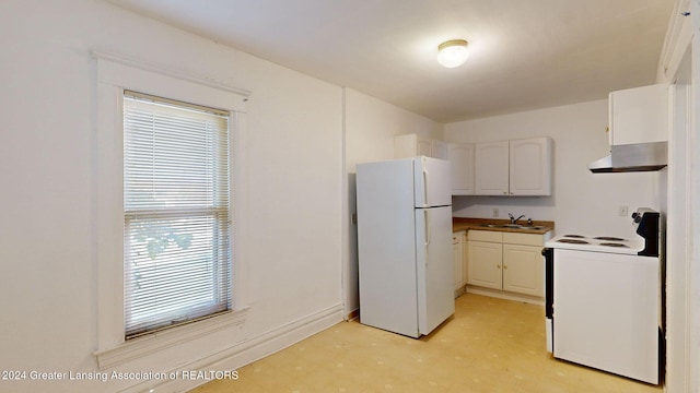 kitchen with a wealth of natural light, white cabinetry, white appliances, and sink