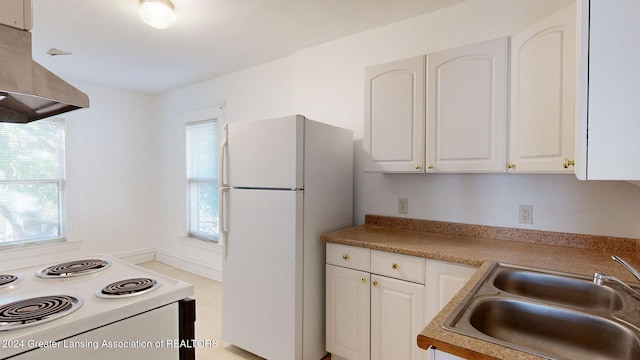 kitchen featuring white appliances, exhaust hood, and white cabinets