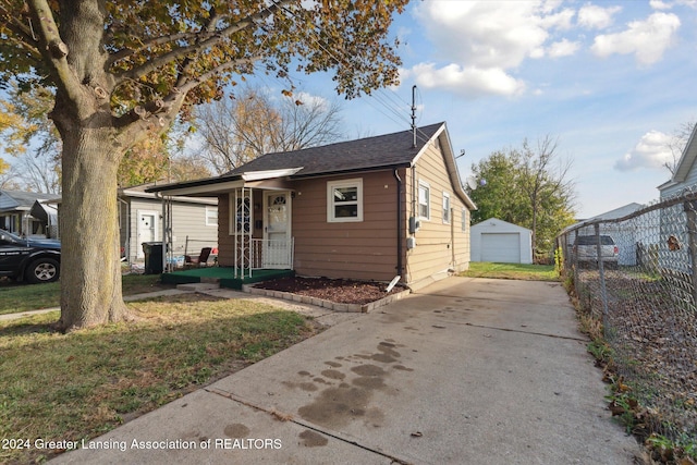 view of front of house with an outdoor structure, a garage, and a front lawn