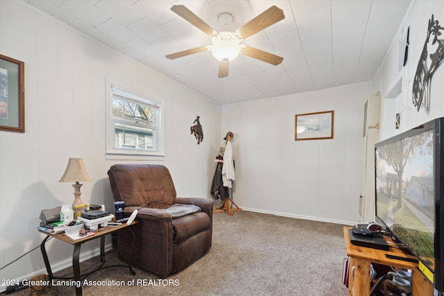 living area with crown molding, carpet flooring, and ceiling fan