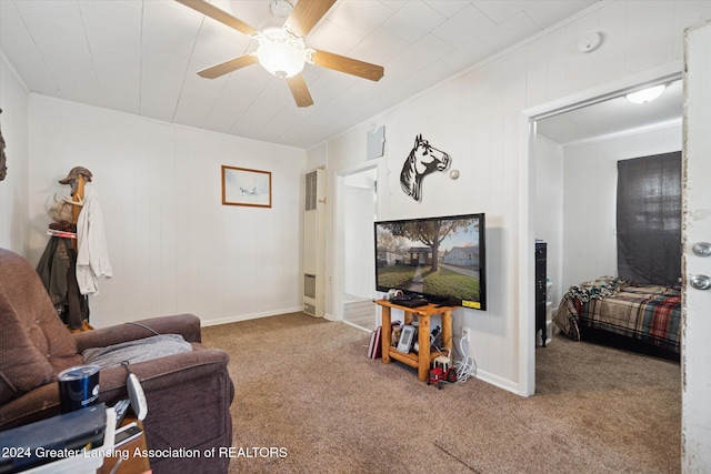 living room with crown molding, carpet flooring, and ceiling fan