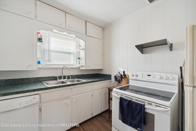 kitchen with white cabinets, dark hardwood / wood-style flooring, sink, wooden walls, and white appliances