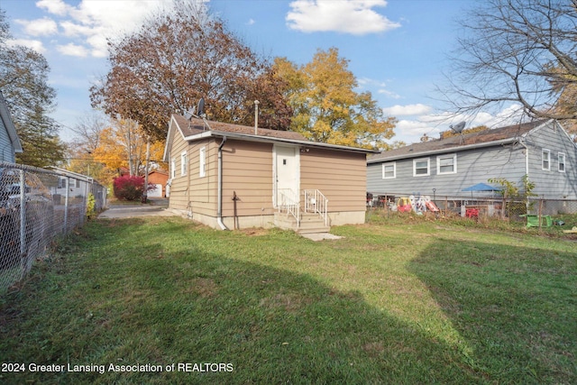 rear view of property featuring a lawn