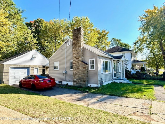 exterior space with a front yard, an outbuilding, and a garage