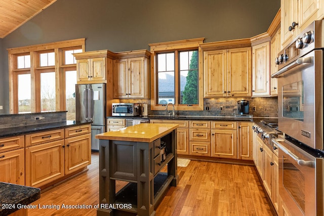 kitchen featuring lofted ceiling, stainless steel appliances, wooden ceiling, wood counters, and light wood-type flooring