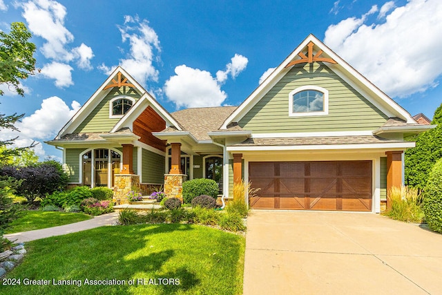 view of front of property with a front lawn, covered porch, and a garage