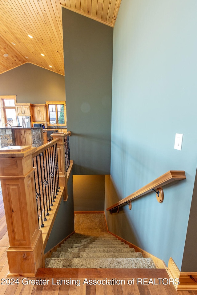 stairs with lofted ceiling, hardwood / wood-style floors, and wood ceiling