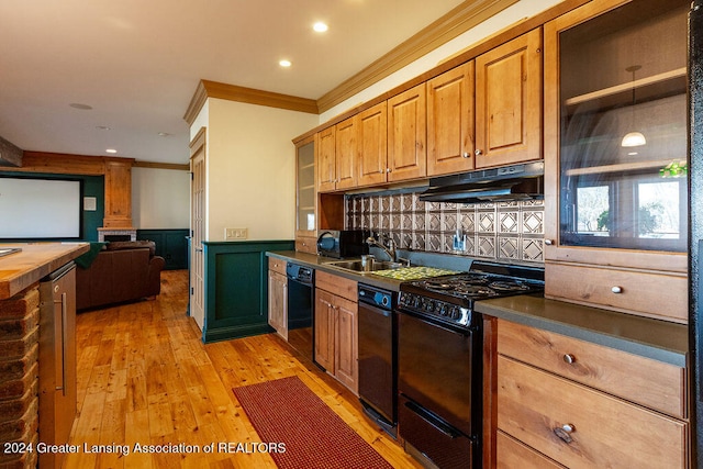 kitchen with tasteful backsplash, ornamental molding, black appliances, light hardwood / wood-style floors, and sink