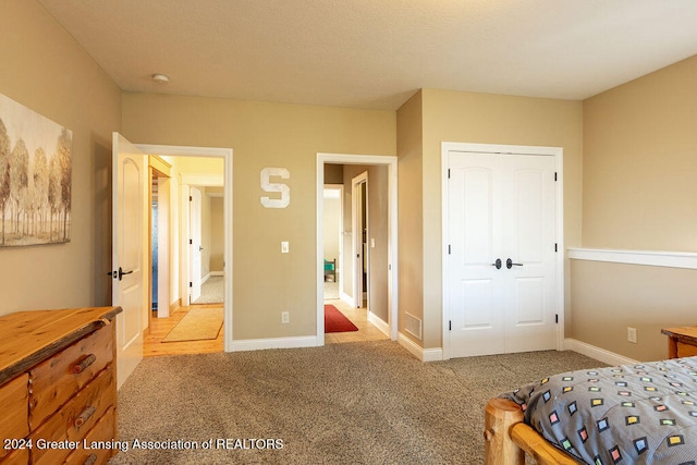 bedroom featuring light colored carpet and a closet