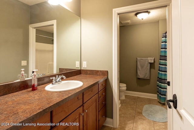 bathroom with toilet, a textured ceiling, vanity, and tile patterned flooring