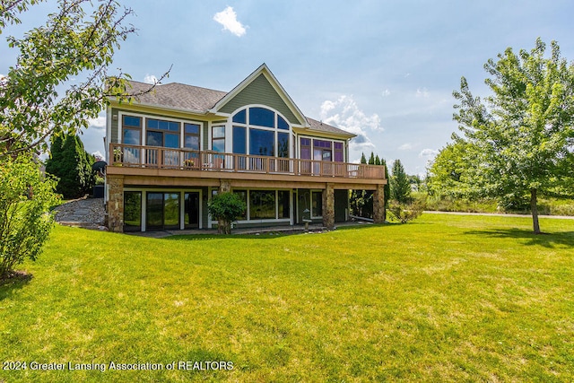 rear view of property featuring a wooden deck and a lawn