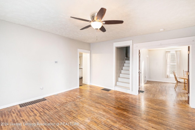 unfurnished room with a textured ceiling, hardwood / wood-style flooring, and ceiling fan