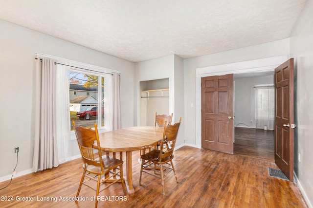 dining space featuring dark hardwood / wood-style floors and a textured ceiling