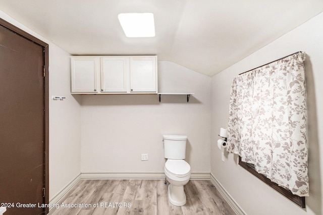 bathroom with toilet, lofted ceiling, and hardwood / wood-style floors