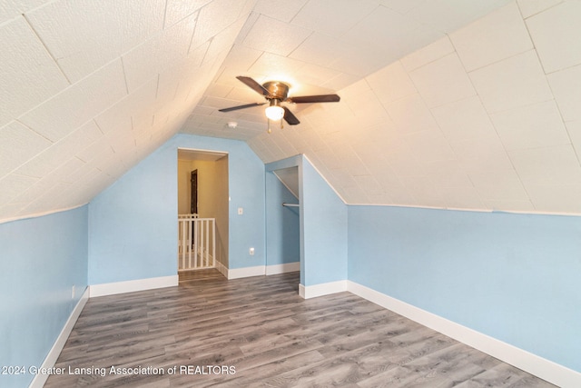 additional living space with ceiling fan, hardwood / wood-style flooring, and vaulted ceiling