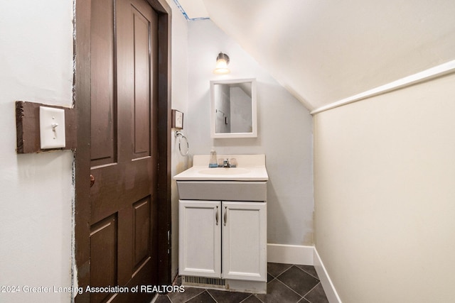 bathroom with vanity, tile patterned flooring, and vaulted ceiling