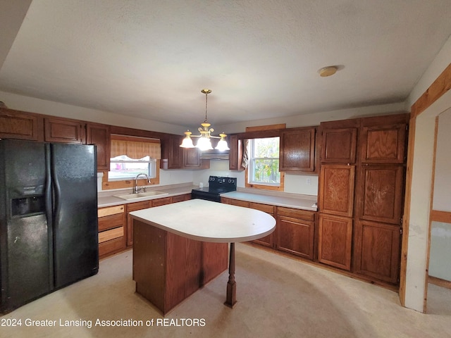 kitchen featuring black appliances, decorative light fixtures, light colored carpet, and plenty of natural light