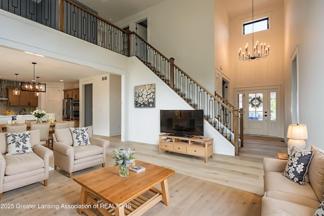 6119 Fresno Ln, East Lansing, MI 48823 - living area with a chandelier, a towering ceiling, plenty of natural light, and light wood-style floors