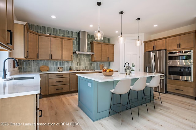 6119 Fresno Ln, East Lansing, MI 48823 - kitchen with wall chimney exhaust hood, appliances with stainless steel finishes, backsplash, light wood-style floors, and brown cabinetry