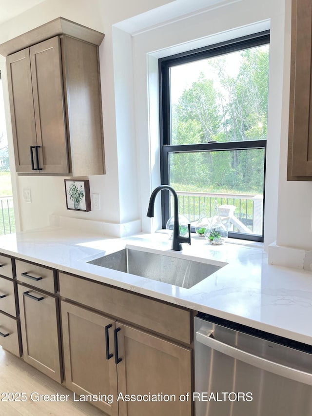 6119 Fresno Ln, East Lansing, MI 48823 - kitchen with stainless steel dishwasher and light stone countertops