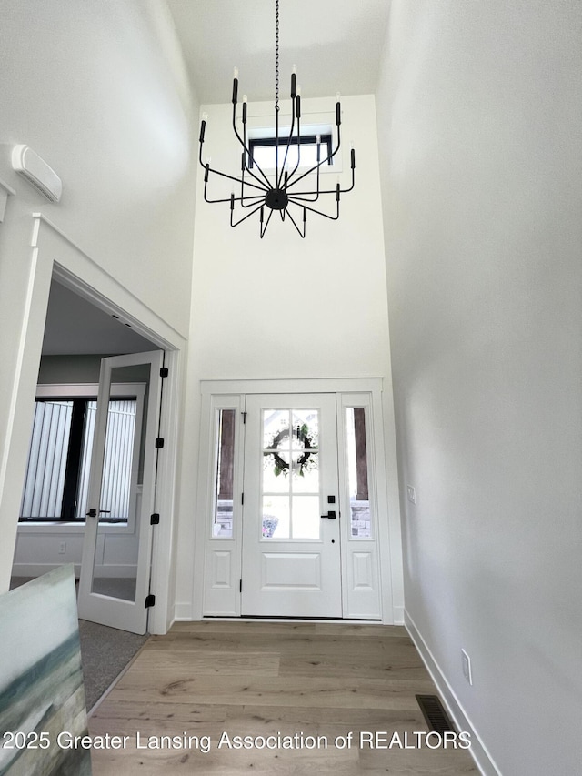 6119 Fresno Ln, East Lansing, MI 48823 - foyer entrance with a chandelier, wood finished floors, and a towering ceiling