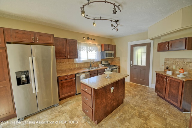 520 W St, Lansing, MI 48915 - kitchen with appliances with stainless steel finishes, a sink, tasteful backsplash, and a kitchen island