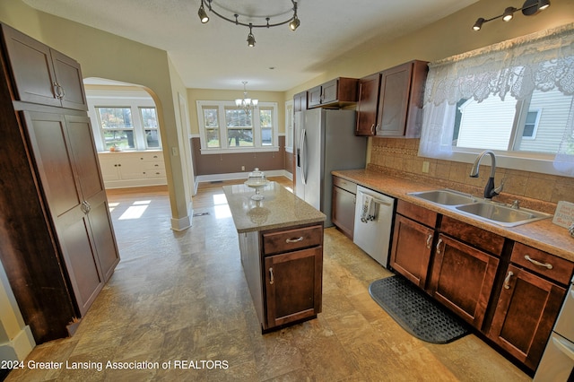 520 W St, Lansing, MI 48915 - kitchen with stainless steel appliances, a sink, a chandelier, arched walkways, and a kitchen island