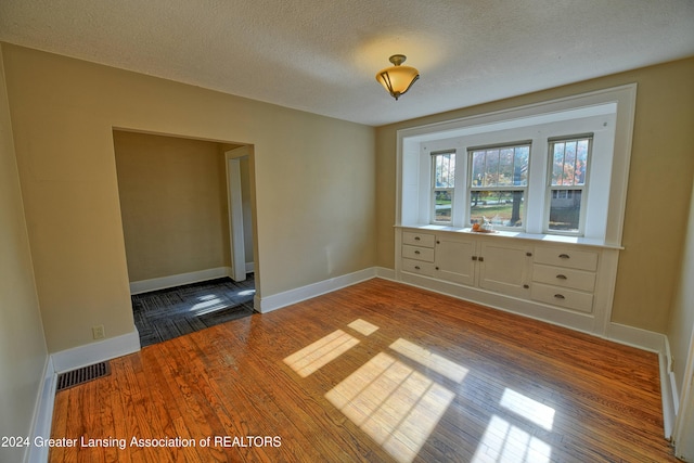 empty room featuring hardwood / wood-style floors and a textured ceiling