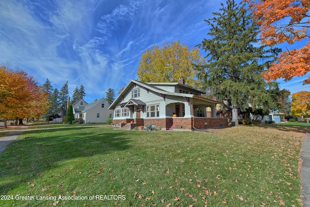 520 W St, Lansing, MI 48915 - craftsman-style home featuring brick siding, a front yard, and a chimney
