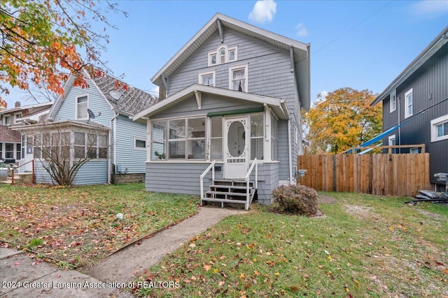 front facade featuring a front yard and a sunroom