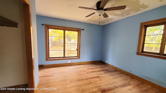 unfurnished room with a wealth of natural light, ceiling fan, and light hardwood / wood-style flooring