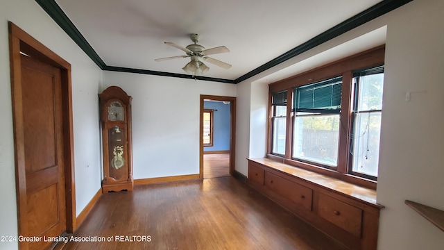 unfurnished room with crown molding, dark hardwood / wood-style floors, and ceiling fan