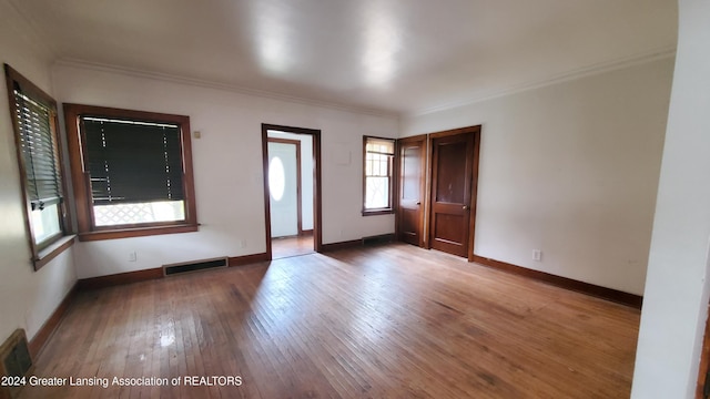 spare room with ornamental molding and hardwood / wood-style floors