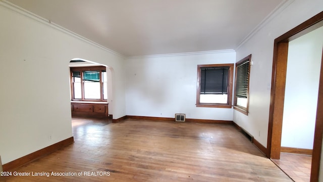 empty room featuring hardwood / wood-style flooring and ornamental molding