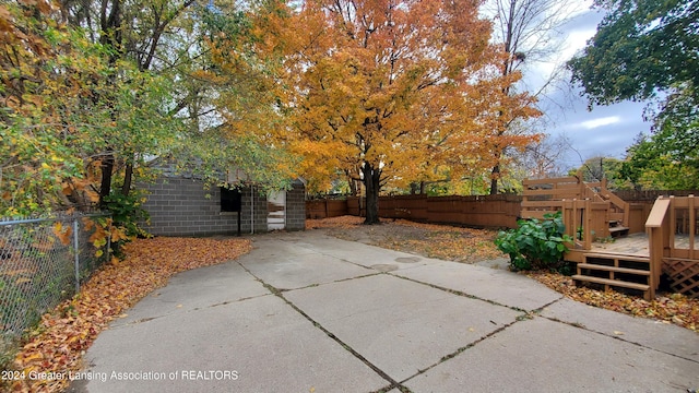 view of patio / terrace featuring a wooden deck and an outbuilding