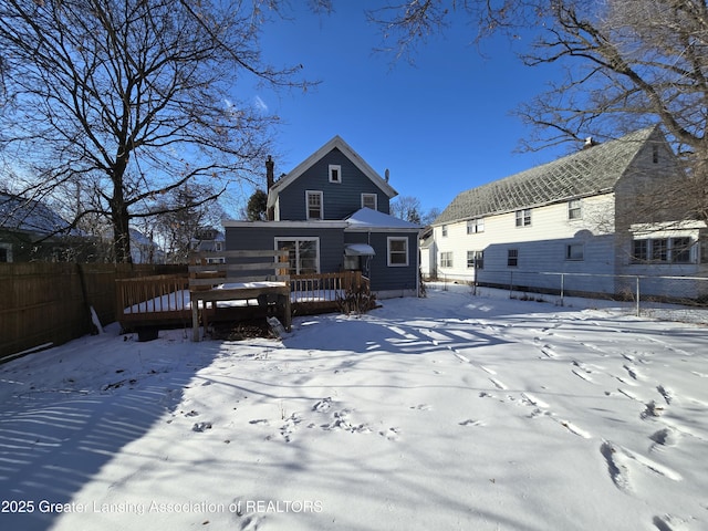 snow covered rear of property featuring a wooden deck