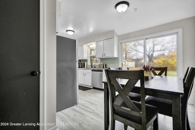 kitchen featuring white cabinets, light hardwood / wood-style floors, sink, and dishwasher