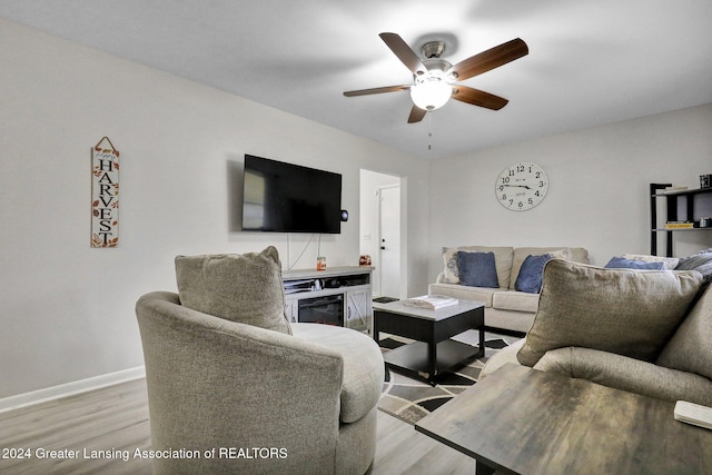 living room featuring ceiling fan and light hardwood / wood-style flooring