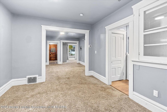 hallway featuring light carpet